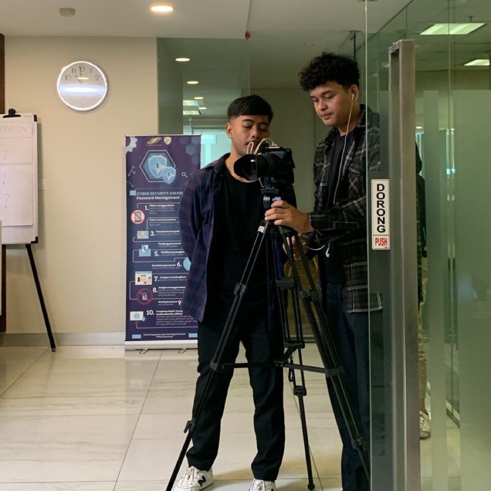 Two crew members setting up a camera on location