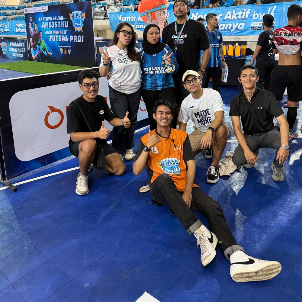 Hoomanist and Sosplan crew at the Piala by.U futsal event, in front of by.U banners