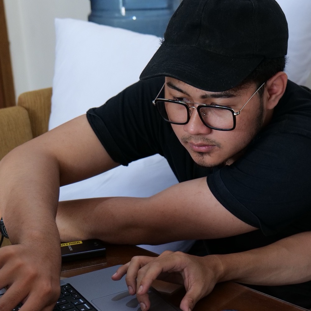 Two people working side by side at a laptop during a session