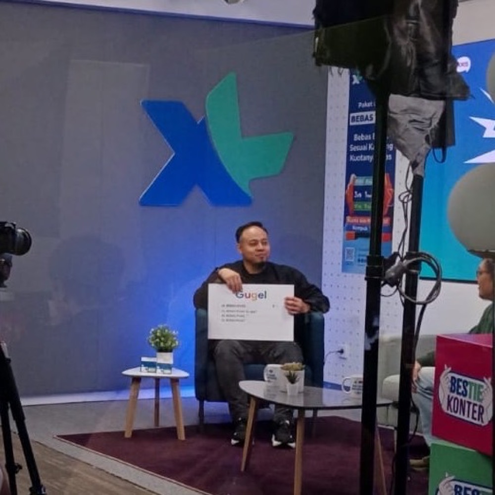 A shoot in progress at the XL office, crew and lighting around the presenter